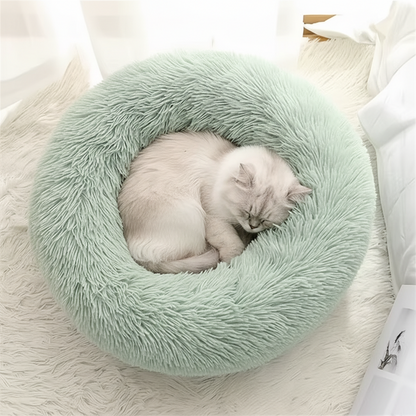 Green calming donut pet bed with sleeping cat