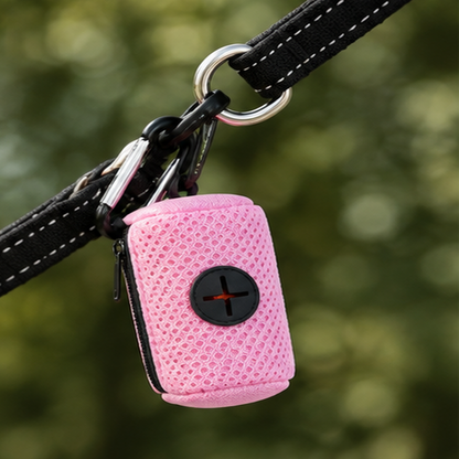 Pink dog waste bag dispenser clipped securely to a dog lead